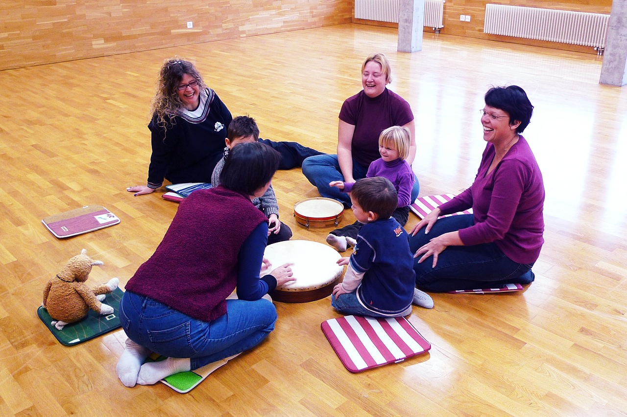foto ouders en kleine kinderen in cirkel met kleine instrumenten